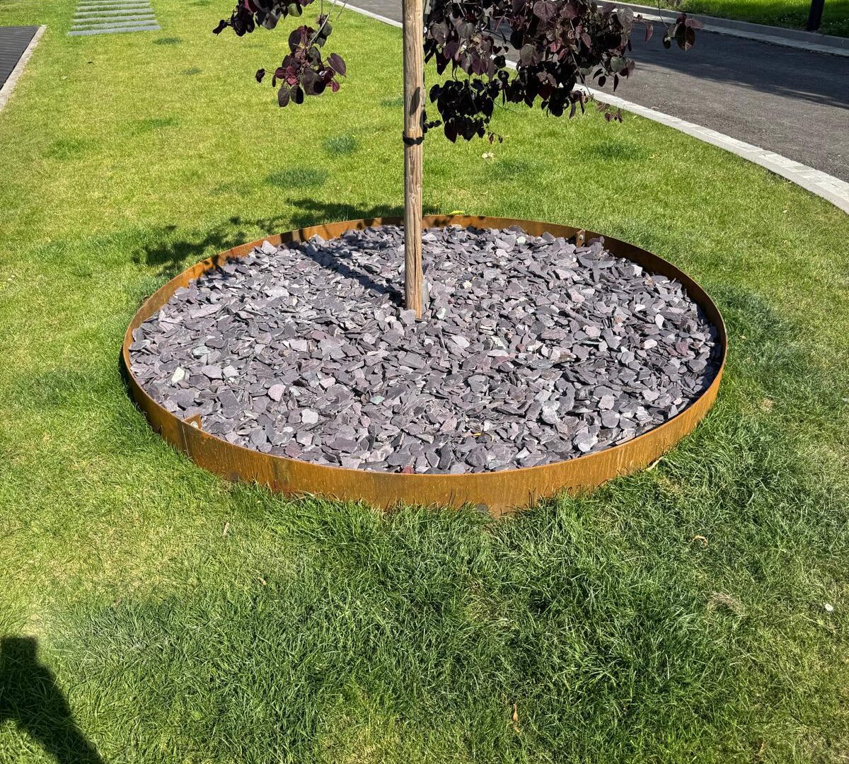 Corten steel tree ring set into a lawn