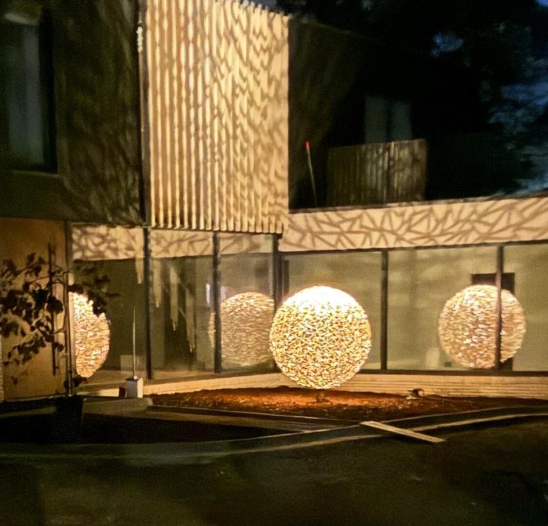 Perforated steel light screens and glowing spheres on a modern house